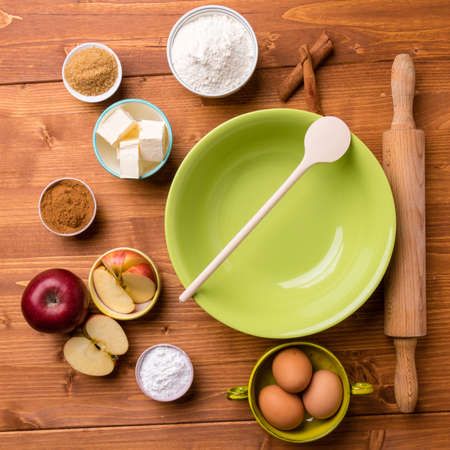 green bowl on wooden table with cooking ingredients