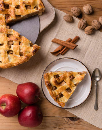 fresh baked apple pie slice on rustic table settingの写真素材