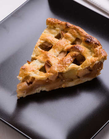 fresh baked apple pie slice on black plateの写真素材