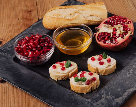 bread with cream cheese pomegranate seeds and honeyの写真素材