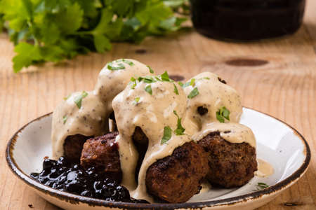 swedish meatballs with blueberry jam on rustic tableの写真素材