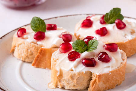 bread with cream cheese and pomegranate seedsの写真素材