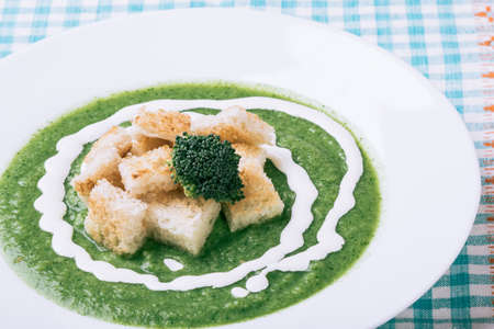 homemade green broccoli cream soup in white plateの写真素材