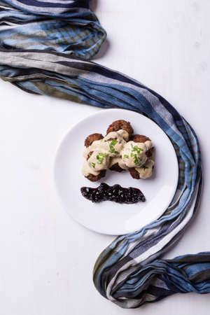 swedish meatballs with blueberry jam on white plate