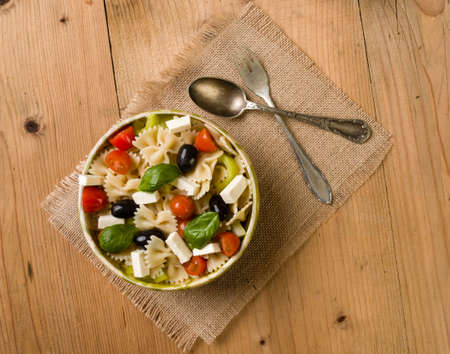 rustic farfalle salad in bowl on wooden tableの写真素材