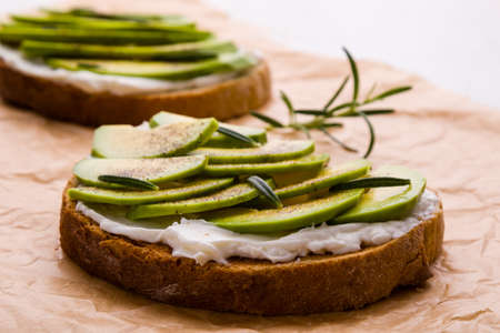 fresh raw sliced avocado sandwich on brown paperの写真素材