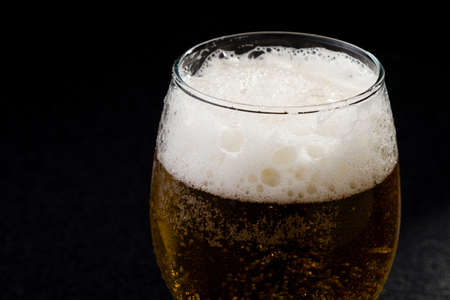 macro shot of fresh cold glass of beer with foamの写真素材