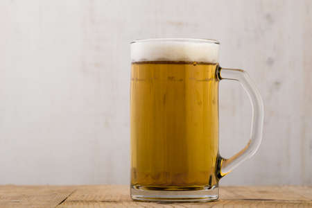 fresh cold glass of beer on wooden tableの写真素材