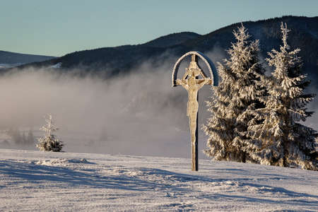 cold winter morning landscape with frozen crucifixの写真素材