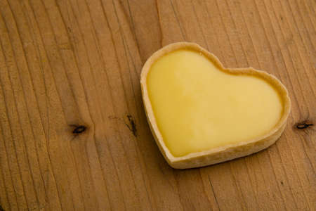 heart shape vanilla tart on rustic wooden table