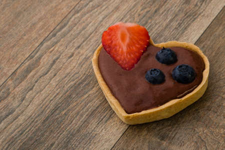 heart shape chocolate tart with strawberry and blueberry