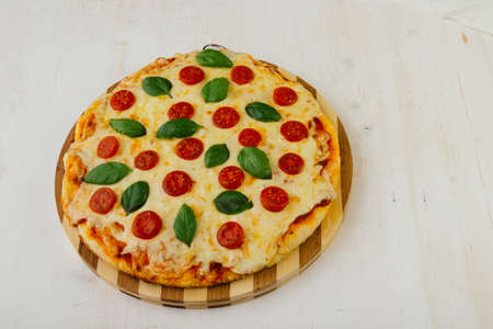 classic pizza margherita on white wooden tableの写真素材