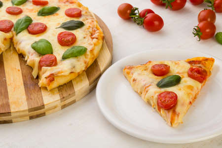 classic pizza margherita slice on white plateの写真素材