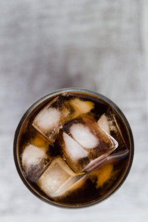 cola, soda in glass with big ice cubes