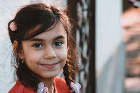 Close-up little girl's face with a smile looking at the cameraの写真素材