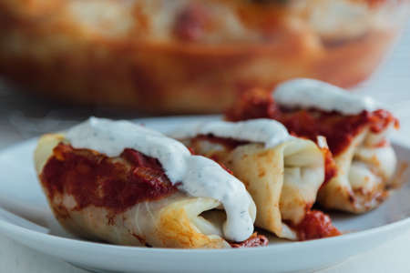 Stuffed cabbage rolls with meat and rice served with tomato sauceの写真素材