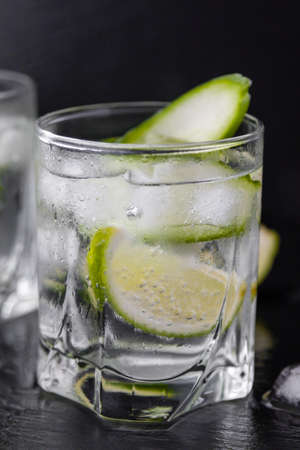 gin tonic with cucumber, lime and ice in glassの写真素材