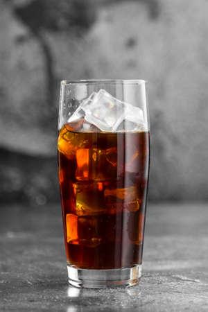 iced brown coffee in tall glass on the tableの写真素材