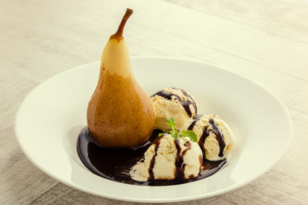 delicious poached pears with syrup and ice creamの写真素材