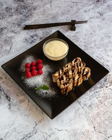 banan pancake sushi dessert with dip and chocolate syrupの写真素材