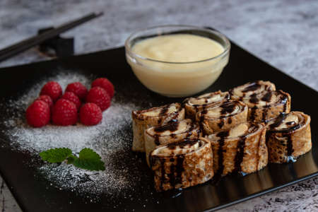 banan pancake sushi dessert with dip and chocolate syrupの写真素材
