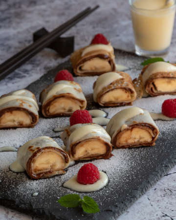 banan pancake sushi dessert with dip and chocolate syrupの写真素材