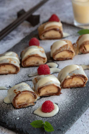 banan pancake sushi dessert with dip and chocolate syrupの写真素材