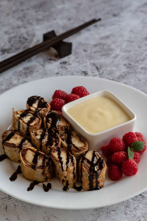 banan pancake sushi dessert with dip and chocolate syrupの写真素材