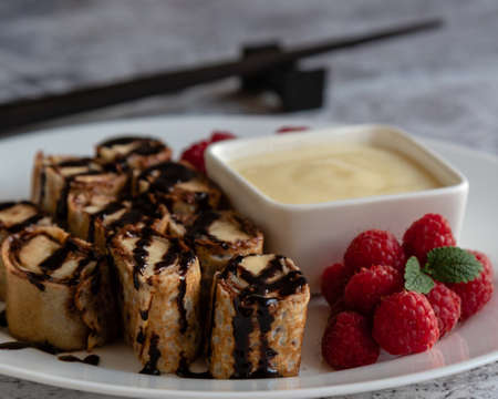 banan pancake sushi dessert with dip and chocolate syrupの写真素材
