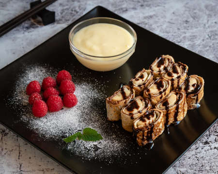 banan pancake sushi dessert with dip and chocolate syrupの写真素材