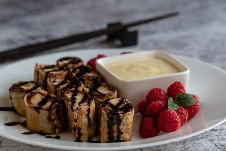 banan pancake sushi dessert with dip and chocolate syrupの写真素材