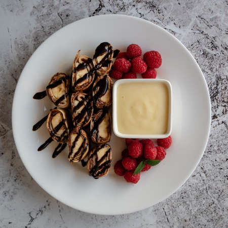 banan pancake sushi dessert with dip and chocolate syrupの写真素材