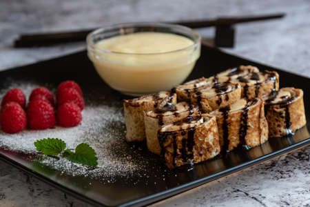 banan pancake sushi dessert with dip and chocolate syrupの写真素材