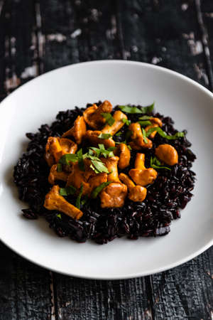 healthy seared girolles mushrooms with black riceの写真素材