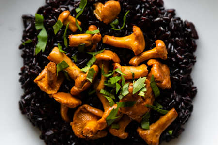 healthy seared girolles mushrooms with black riceの写真素材
