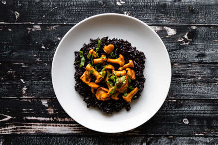 healthy seared girolles mushrooms with black riceの写真素材