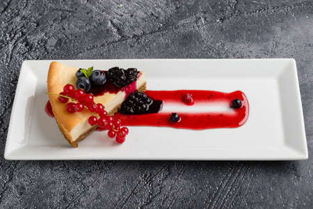 fresh tasty cheese cake with fruits on white plateの写真素材