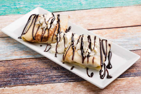 european pancakes, sweet crepe with topping on white long plateの写真素材