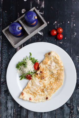 filled omelette with cheese and tomato on white plateの写真素材