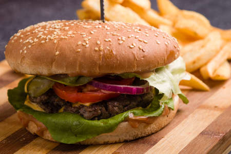tasty rustic hamburger with fries on wooden tableの写真素材