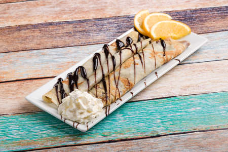 european pancakes, sweet crepe with topping on white long plateの写真素材