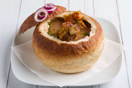 tasty delicious bean soup with smoked meat in breadの写真素材