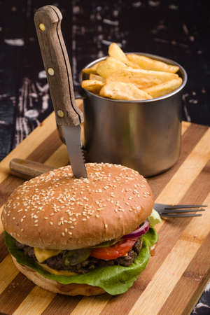 tasty rustic hamburger with fries on wooden tableの写真素材