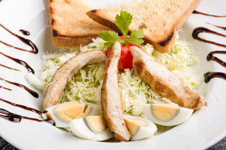 fresh tasty caesar salad appetizer in white plateの写真素材