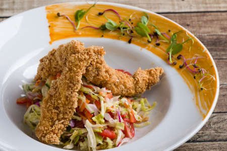tasty crispy chicken salad appetizer in white plateの写真素材