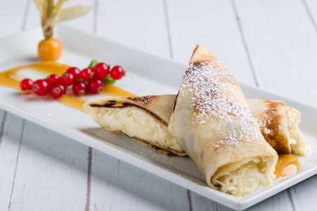 european pancakes, sweet crepe with topping on white long plateの写真素材