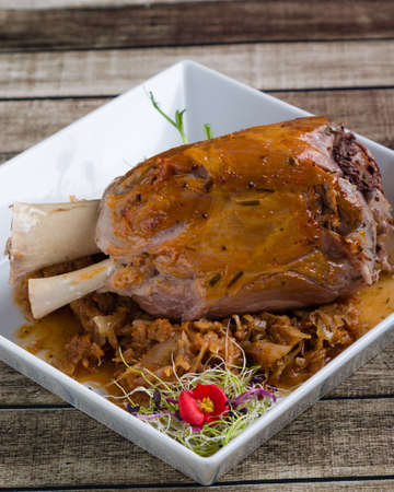 bavarian pork knuckle with cabbage on white plateの写真素材