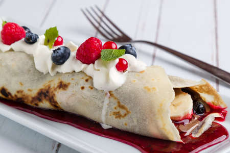 european pancakes, sweet crepe with topping on white long plateの写真素材