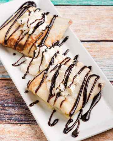 european pancakes, sweet crepe with topping on white long plateの写真素材