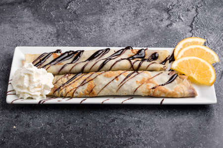 european pancakes, sweet crepe with topping on white long plateの写真素材